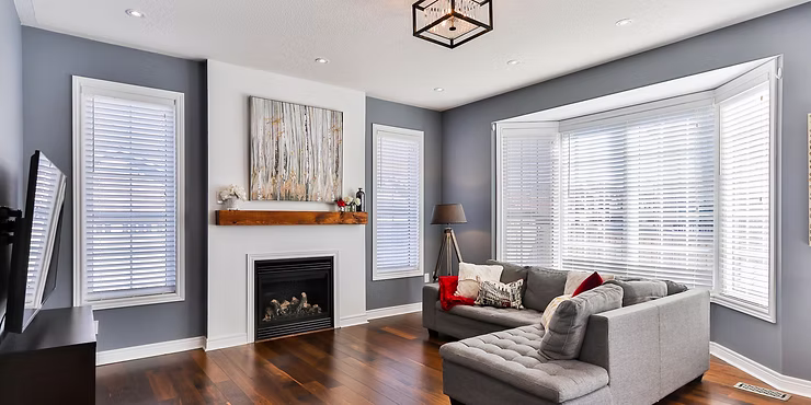 Modern living room with gray walls, a fireplace and neutral furniture