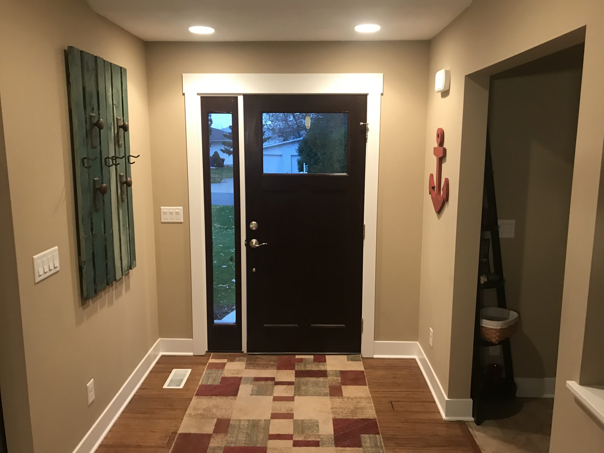 Freshly painted hallway with a dark entry door in a Michigan home during winter