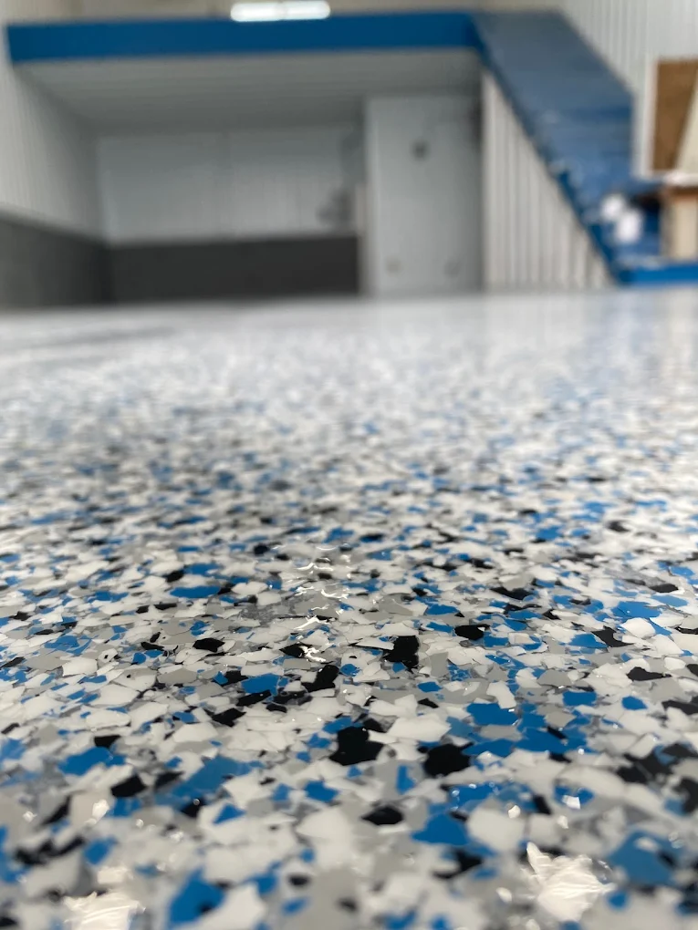 Garage floor with a decorative flake epoxy coating in blue, gray and black tones