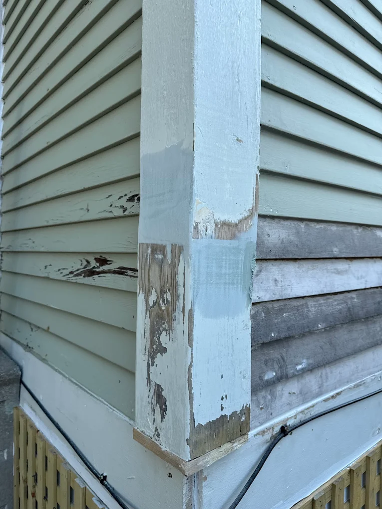 Weathered siding and trim on a home exterior with worn, peeling paint
