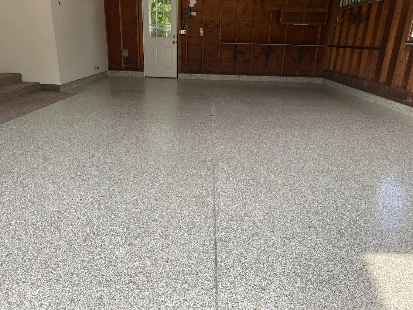 Speckled decorative garage floor coating in grey tones inside a Michigan garage