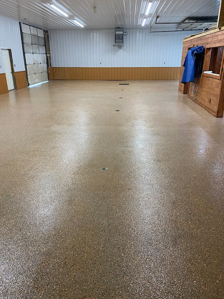 Garage with a professionally coated speckled floor, wood wall panels and hanging jackets along the wall