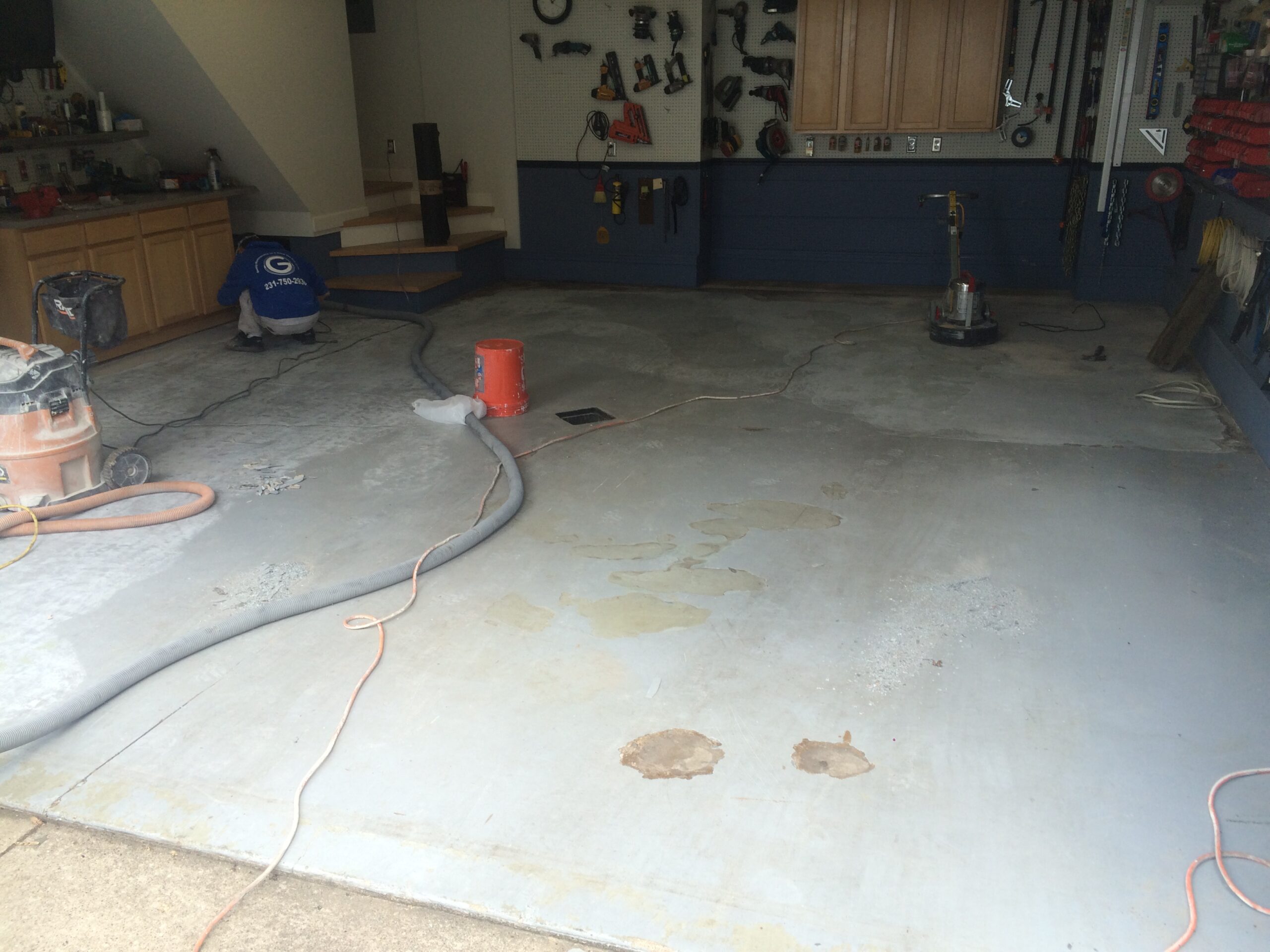 Garage floor being prepared with painting equipment and tools